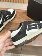 Amiri sneaker front view, black glitter with white logo panel and toe, lace-up sole