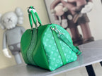 Green Louis Vuitton monogram duffel-style handbag with double handles and strap.