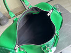 Green Louis Vuitton handbag interior view with zip opening and smooth lining.