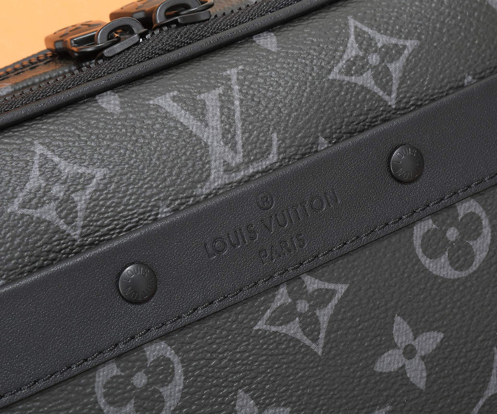 Louis Vuitton monogram crossbody bag close-up of embossed pattern and snap button strip, dark