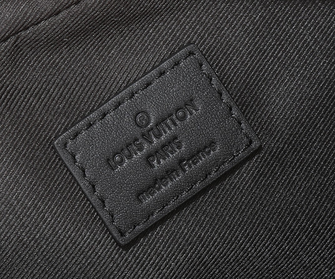Louis Vuitton branded leather tag on monogram crossbody bag, embossed logo, dark gray