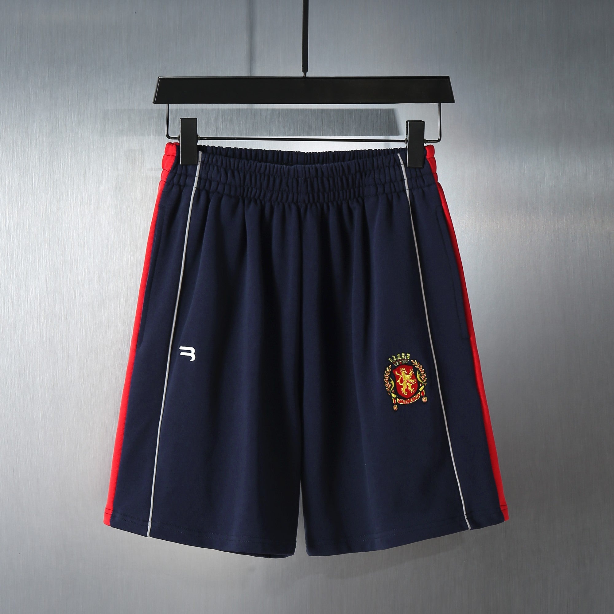 Navy shorts with elastic waistband and embroidered crest logo on the front leg
