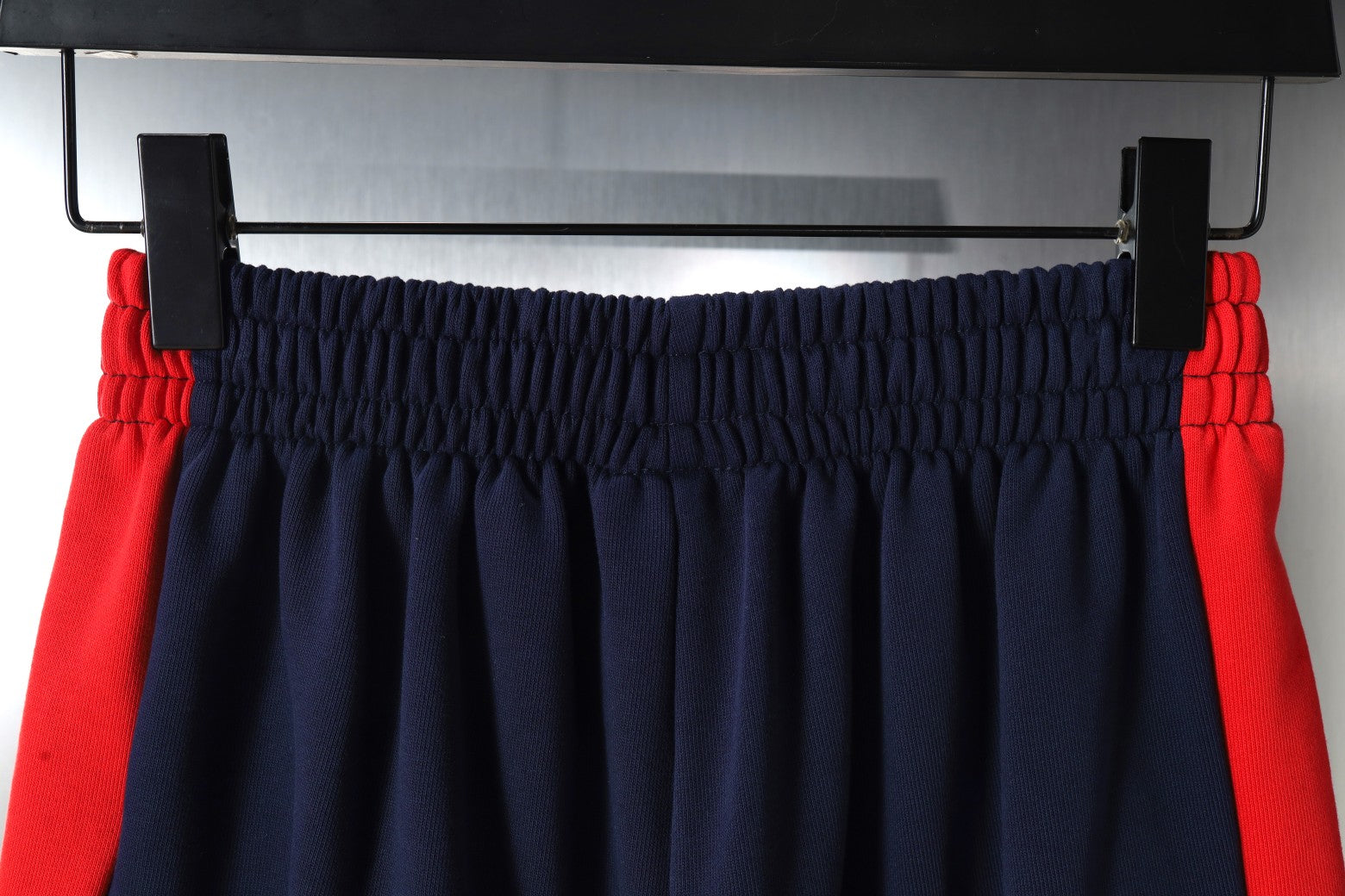 Navy shorts with red side stripes and elastic waistband