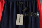 Balenciaga tags hanging from navy shorts with red side trim