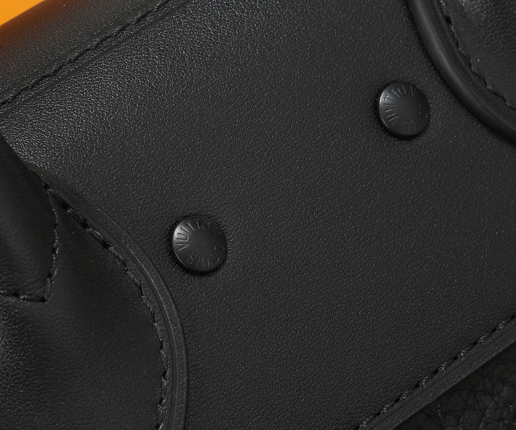 Black leather satchel front with snap buttons and textured panel