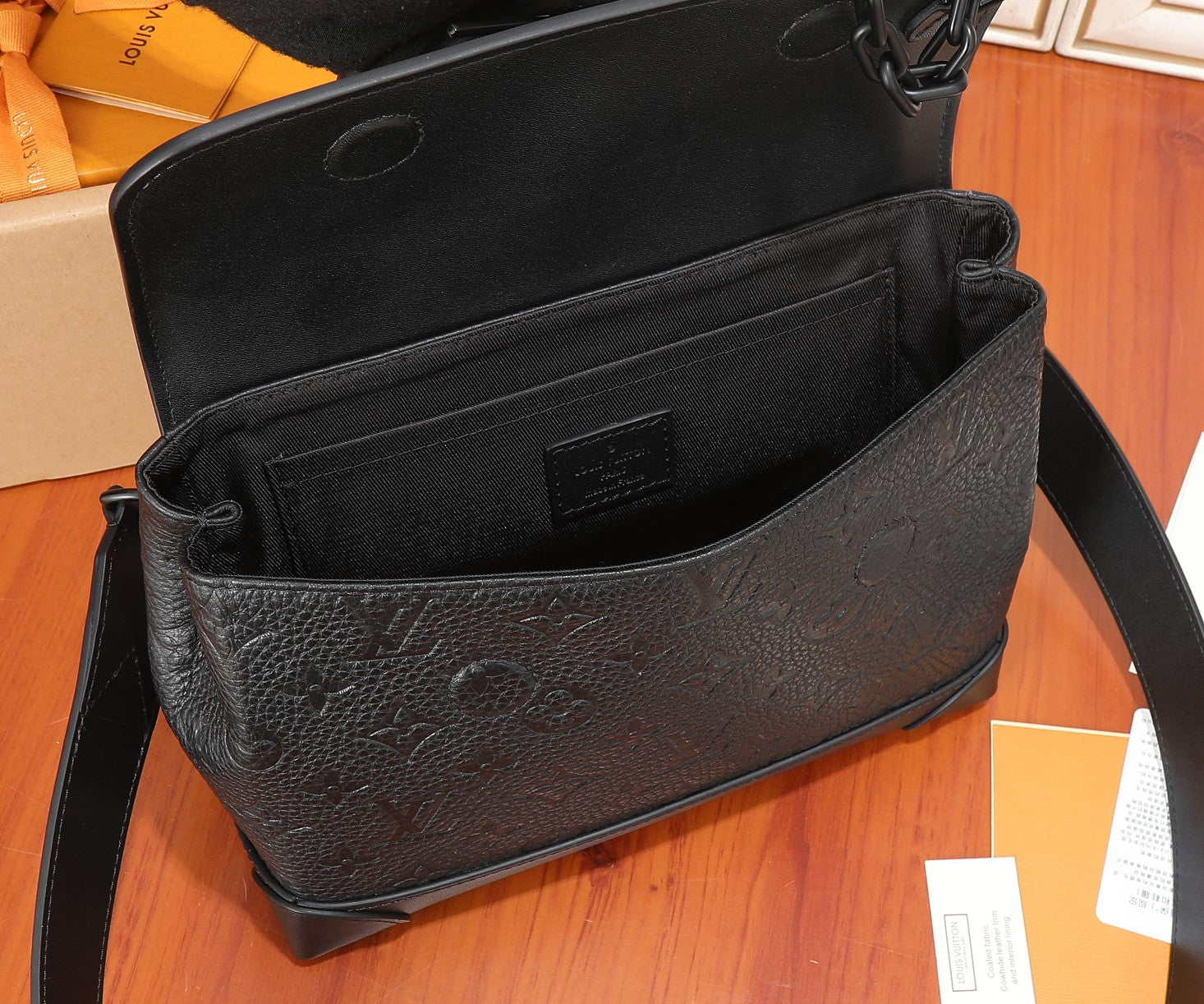 Louis Vuitton leather bag open, showing interior lining and front pocket panel