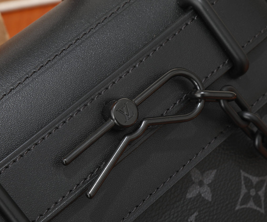Louis Vuitton men's bag hardware close-up: metal clasp on dark leather strap.