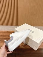 Alexander McQueen white leather sneakers, side view with laces and perforations