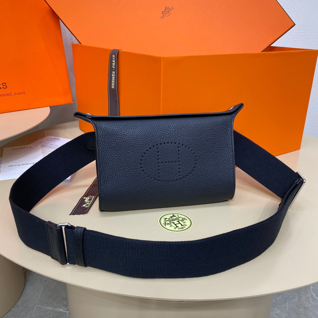 Hermes crossbody bag in dark blue leather with front logo and adjustable web strap.