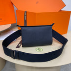 Hermes crossbody bag in dark blue leather with front logo and adjustable web strap.
