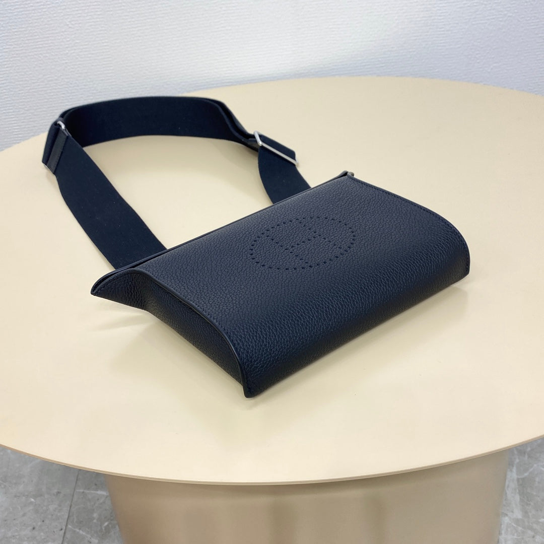Hermes crossbody bag in dark blue pebbled leather with front logo and strap.