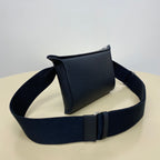 Hermes crossbody bag in dark blue leather with curved flap and adjustable strap.