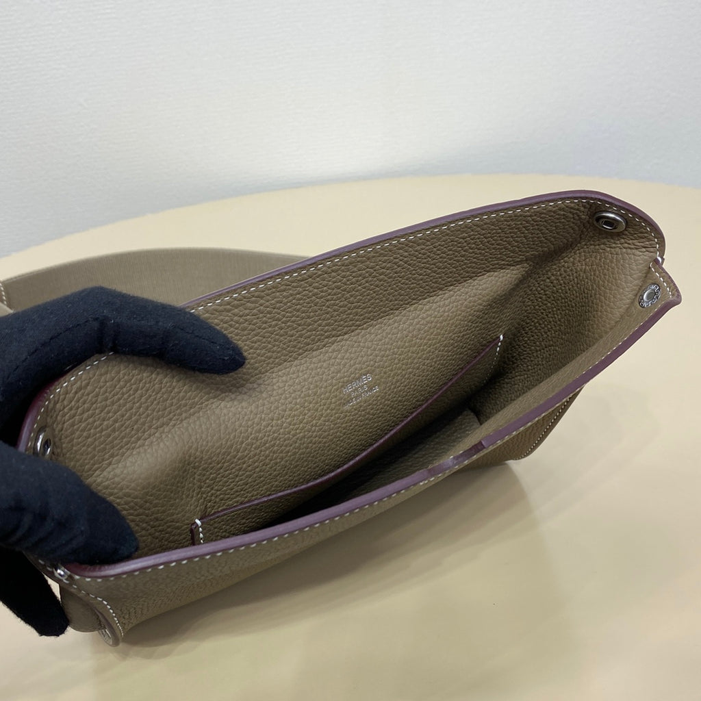 Hermes taupe crossbody bag side view with dark lining and silver zipper pull