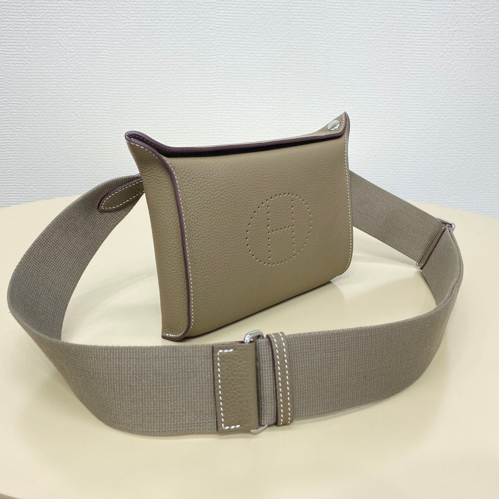 Hermes crossbody bag with taupe front panel, stitched edges, and gray adjustable strap