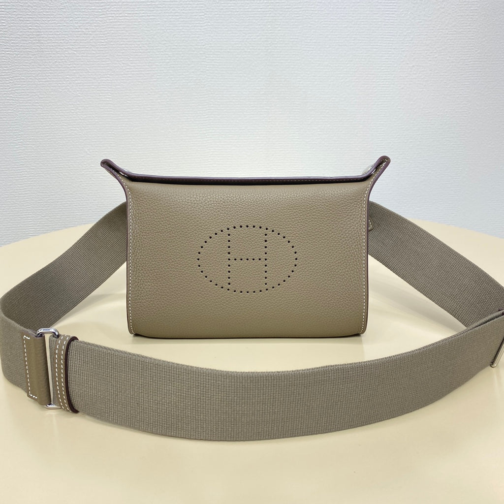 Hermes crossbody bag with taupe front logo and gray strap with metal buckle