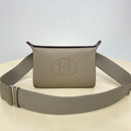 Hermes crossbody bag with taupe front logo and gray strap with metal buckle