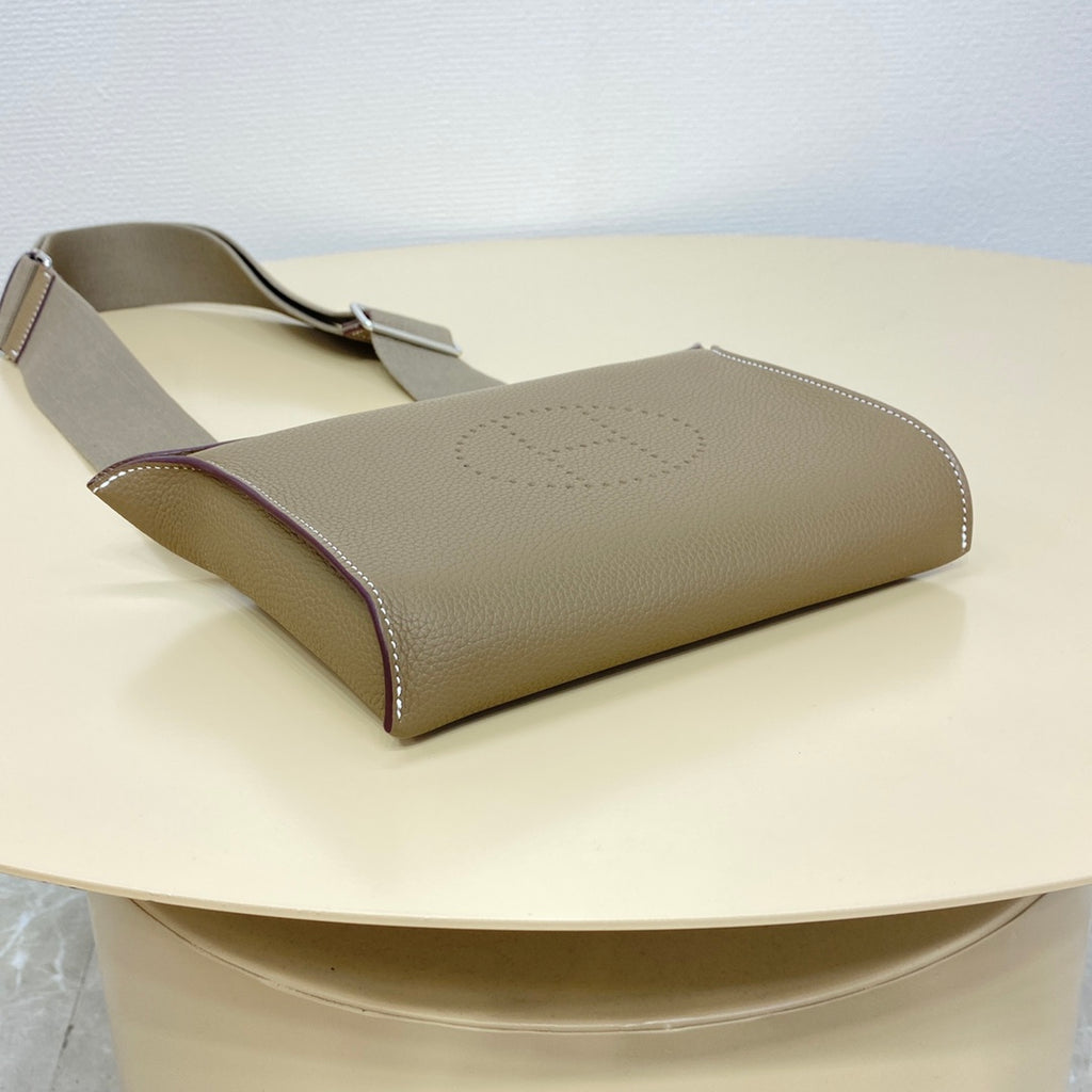 Hermes taupe leather crossbody bag with gray strap and front H-stamp on flap