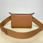 Hermes crossbody bag in tan leather with front logo stamp and canvas strap