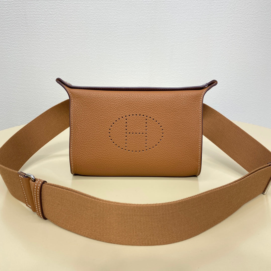 Hermes crossbody bag in tan leather with front logo stamp and canvas strap