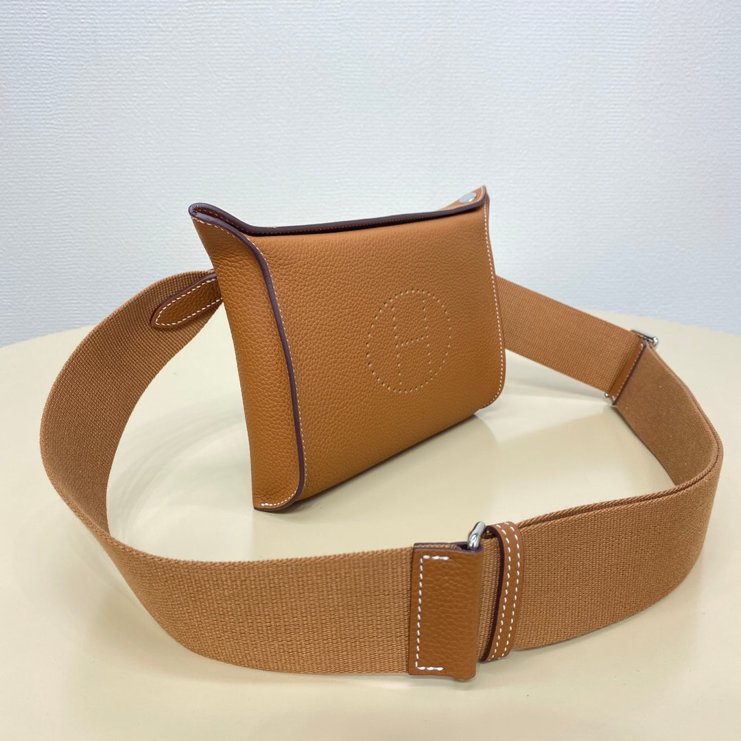 Hermes crossbody bag with tan leather body and adjustable web strap, side view
