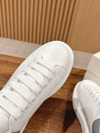 Alexander McQueen white leather sneaker toe and laces, close-up view