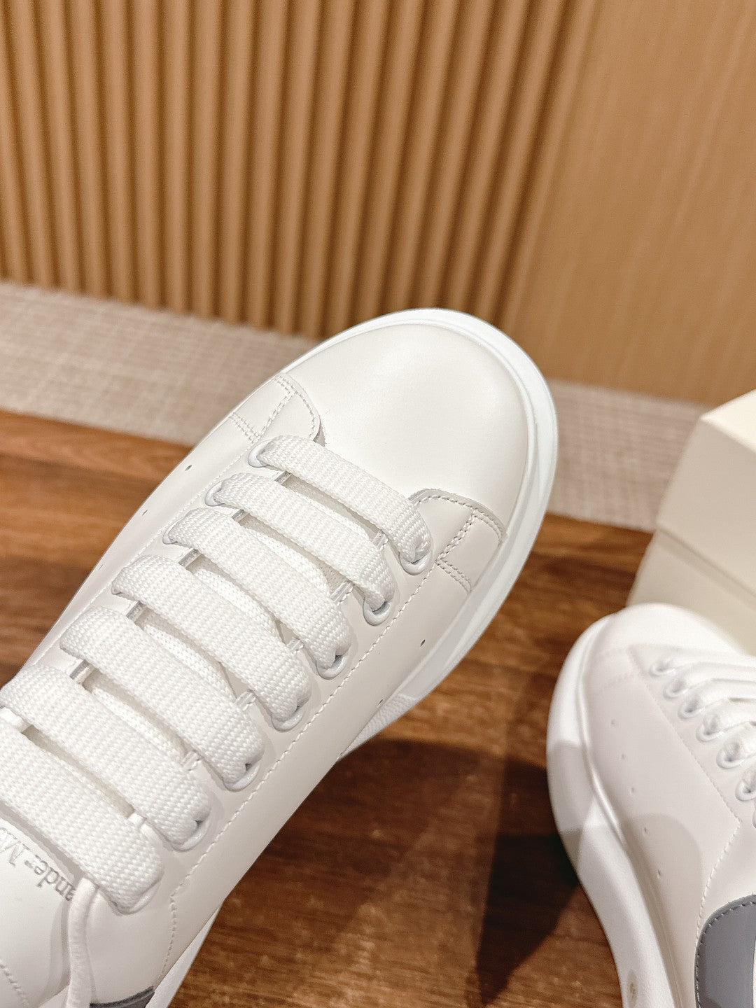Alexander McQueen white leather sneaker toe and laces, close-up view