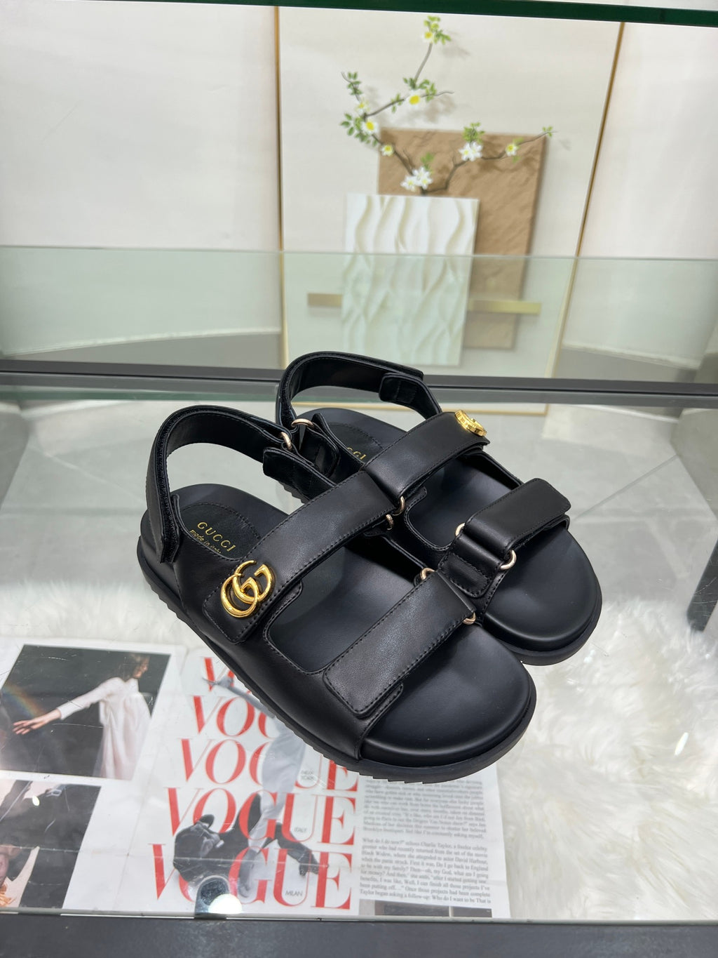 Gucci black sandals with two wide straps and gold-tone emblem on front