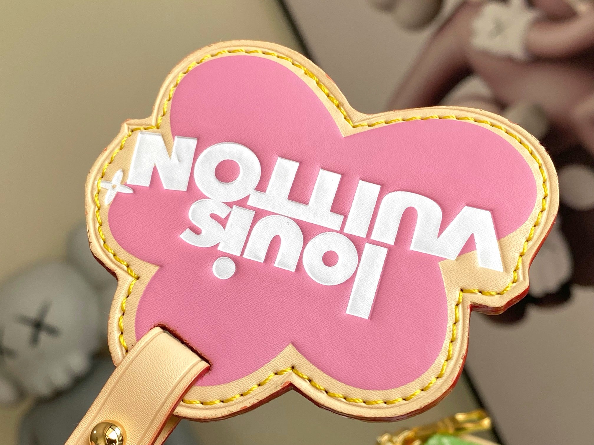 Louis Vuitton pink cow-shaped charm with "No milk" text and stitched yellow border