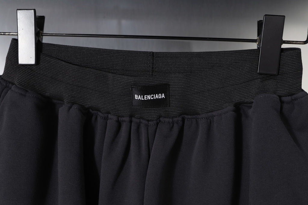 Balenciaga waistband close-up with logo, dark pleated fabric