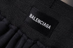Balenciaga fabric label on elastic waistband of dark shorts