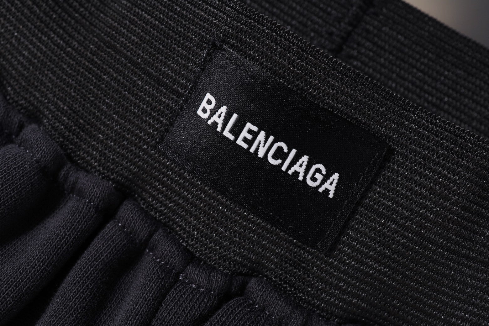 Balenciaga fabric label on elastic waistband of dark shorts
