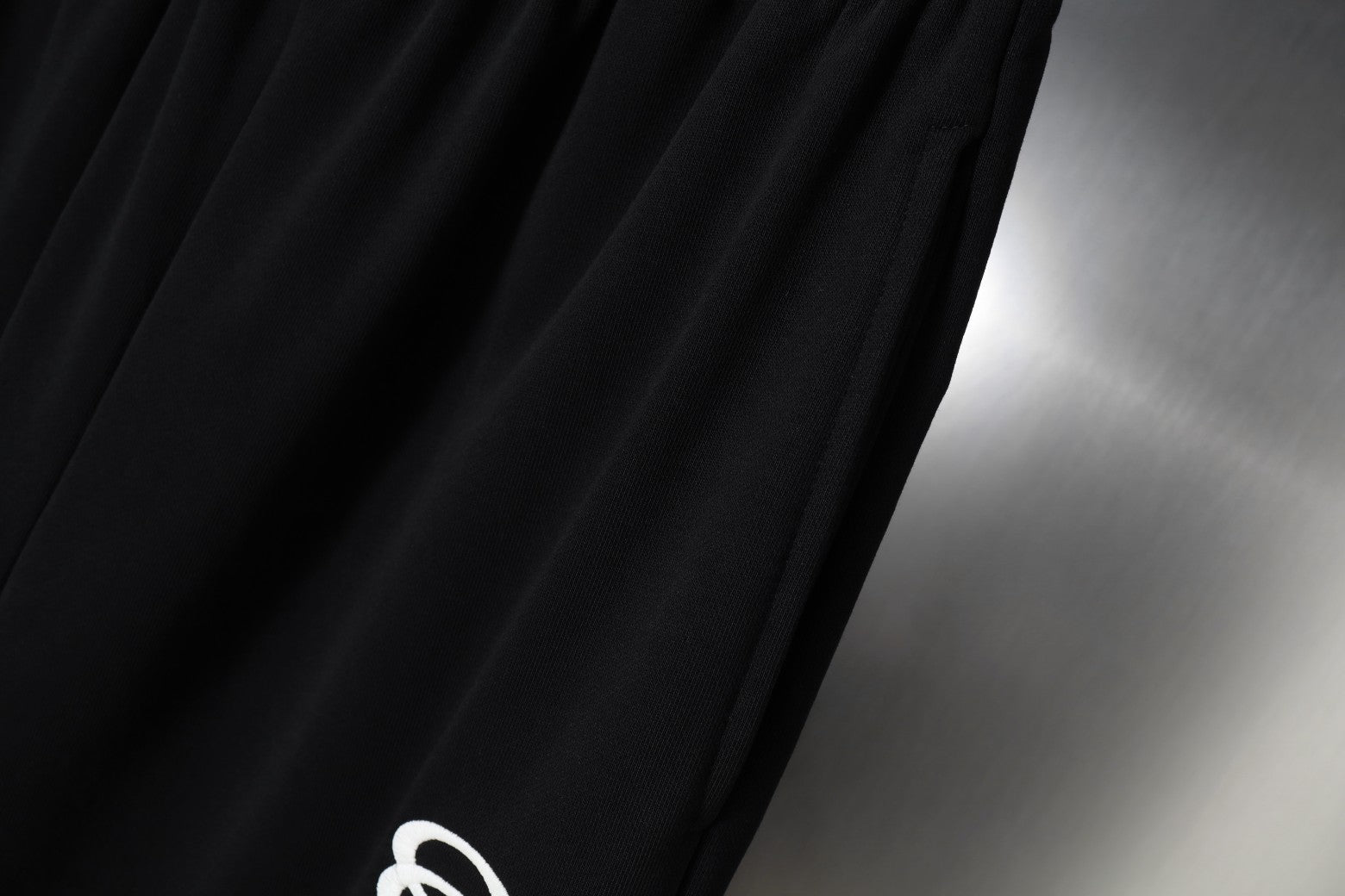 Black fabric with smooth drape and fine stitched texture