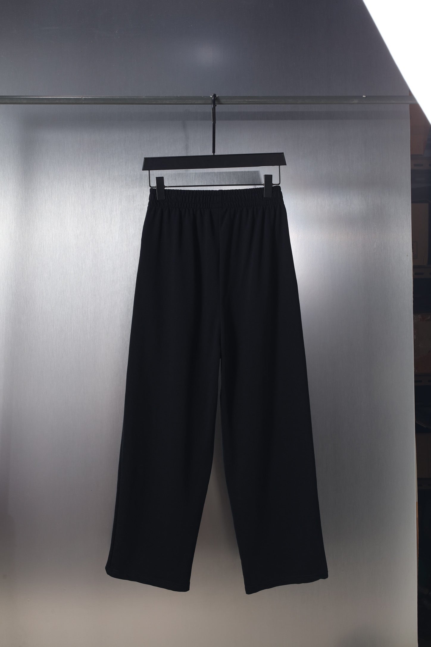Black wide-leg pants with elastic waistband and small logo on the front thigh