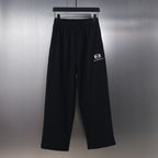 Black wide-leg pants with elastic waistband and small white Balenciaga logo print