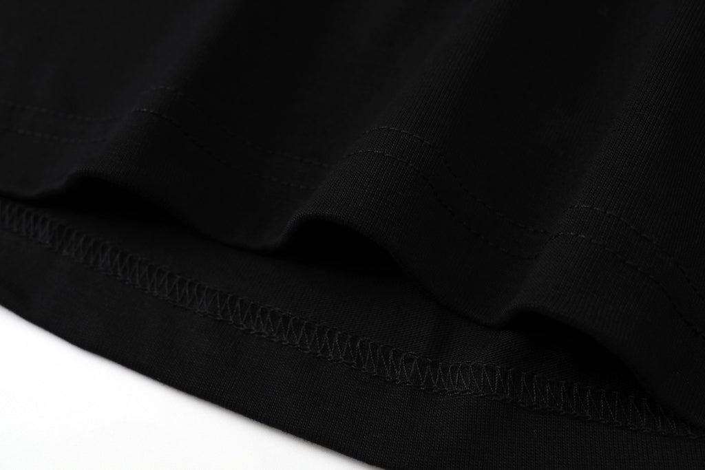 Black hem with fine stitching and gathered fabric edge