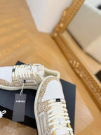 Amiri sneakers close-up: white and gold glitter upper with white lace-up front