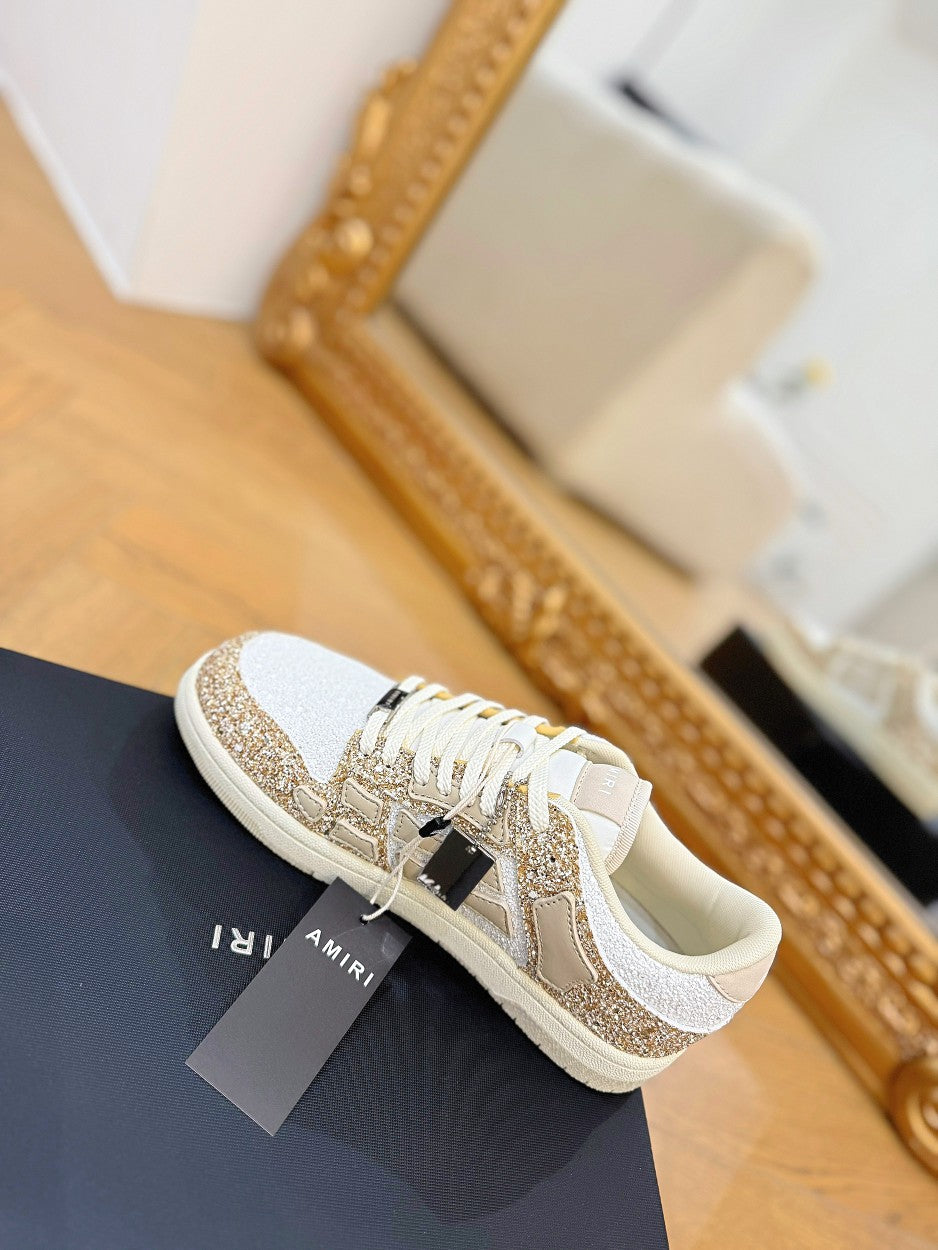 Amiri low-top sneakers with white leather, gold glitter side stripe, lace-up design