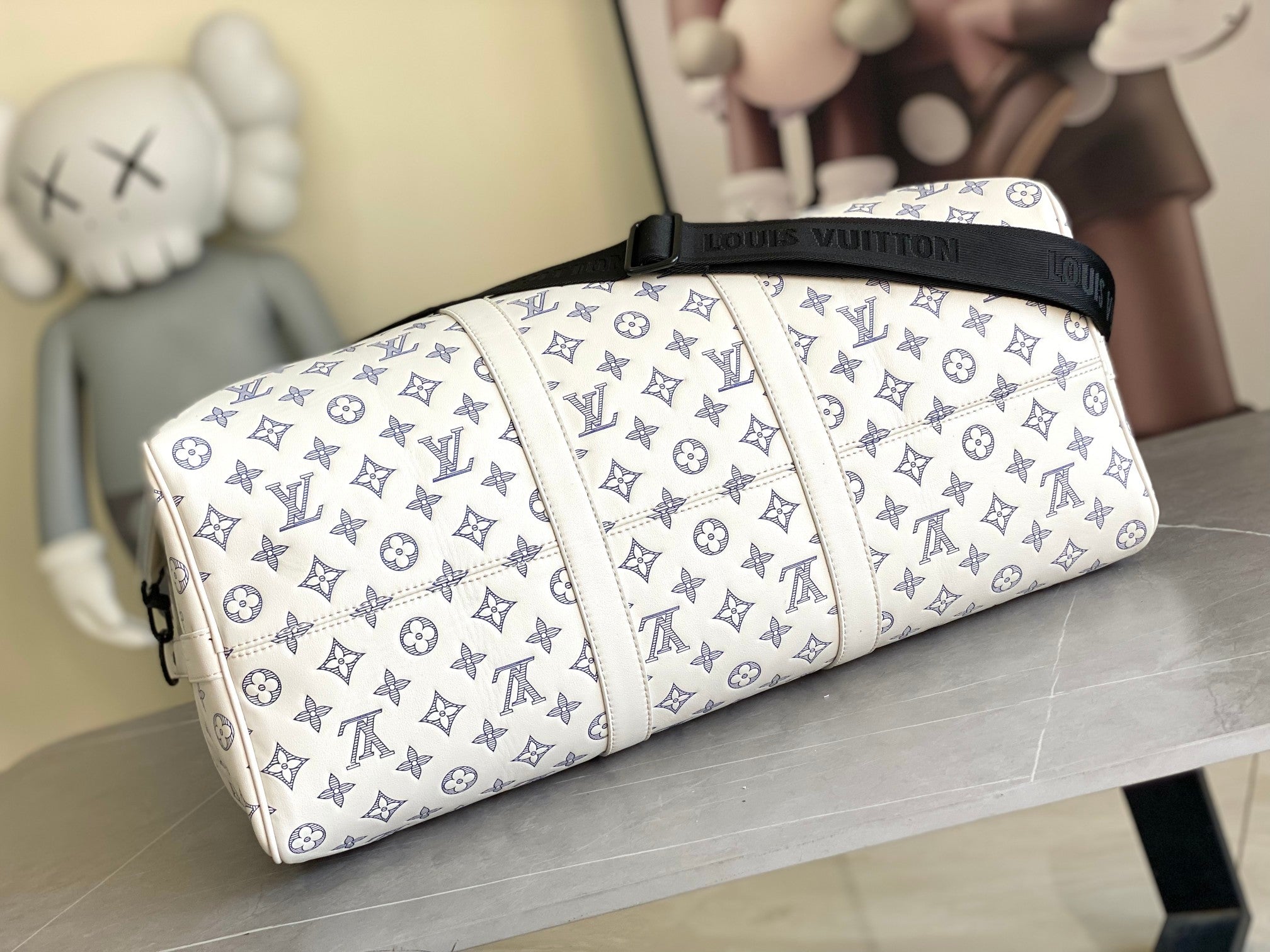 Louis Vuitton monogram duffel bag with navy-trimmed top and white handles