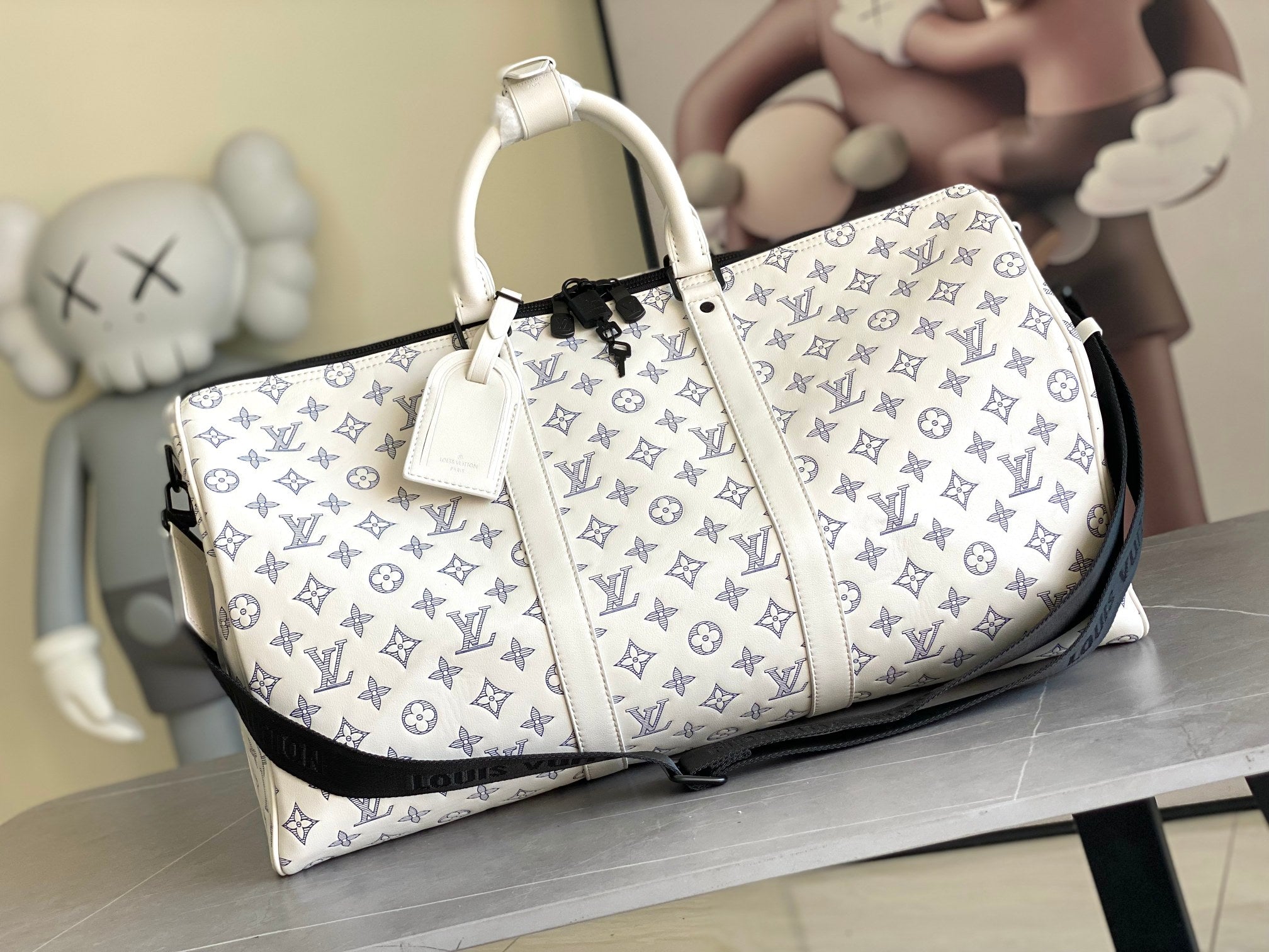 Louis Vuitton monogram duffel bag with white leather trim and blue pattern, top handles