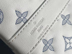 Close-up of white leather panel with blue monogram print and embossed logo lettering