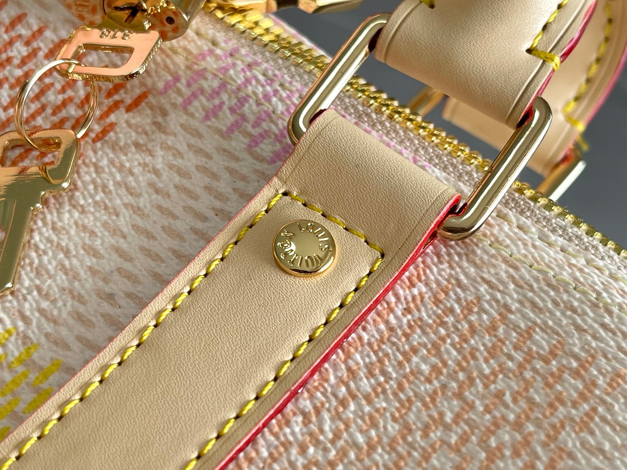 Louis Vuitton strap hardware on cream leather with gold-tone buckle and stitching