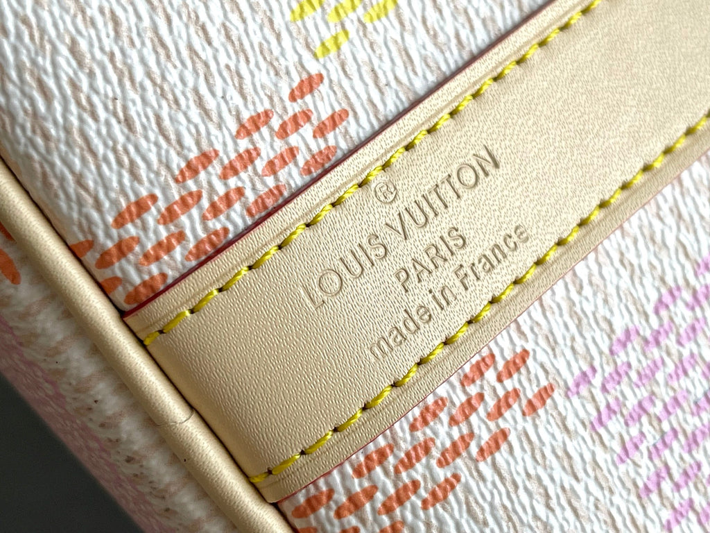 Louis Vuitton logo leather patch on cream lining with gold text and yellow stitching
