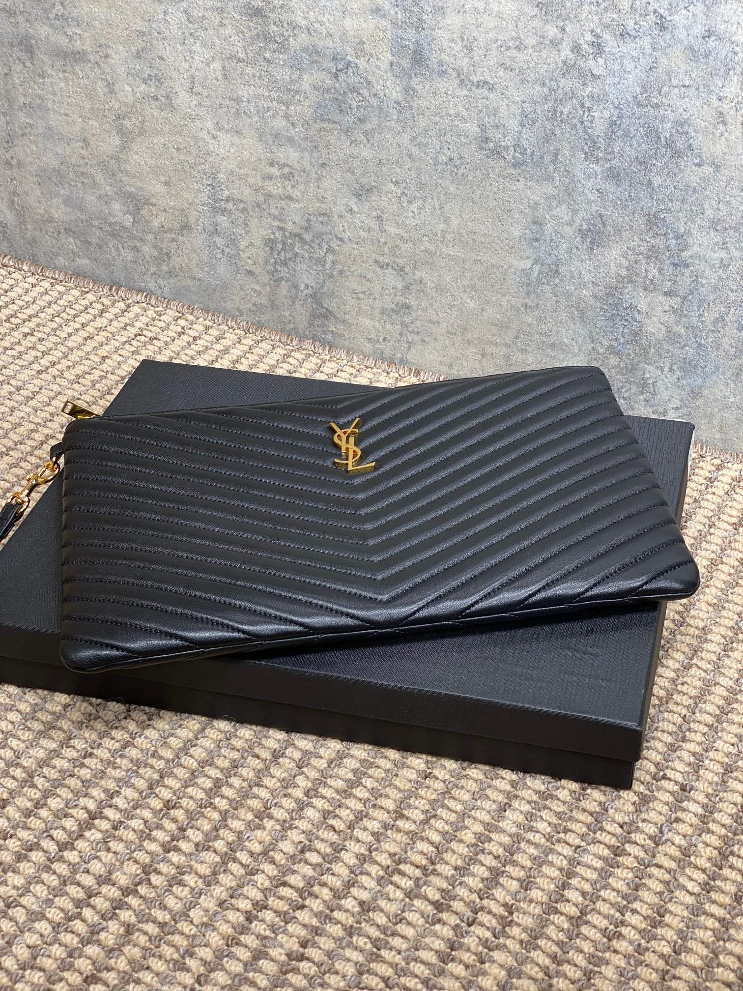 Small quilted clutch bag with YSL logo on flap, black leather with gold trim