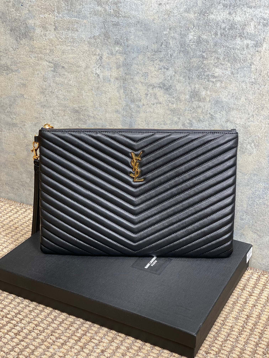 Small quilted clutch bag with YSL logo, black exterior and gold-tone hardware