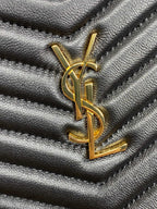 Close-up of YSL logo on black quilted bag with gold-tone metal hardware