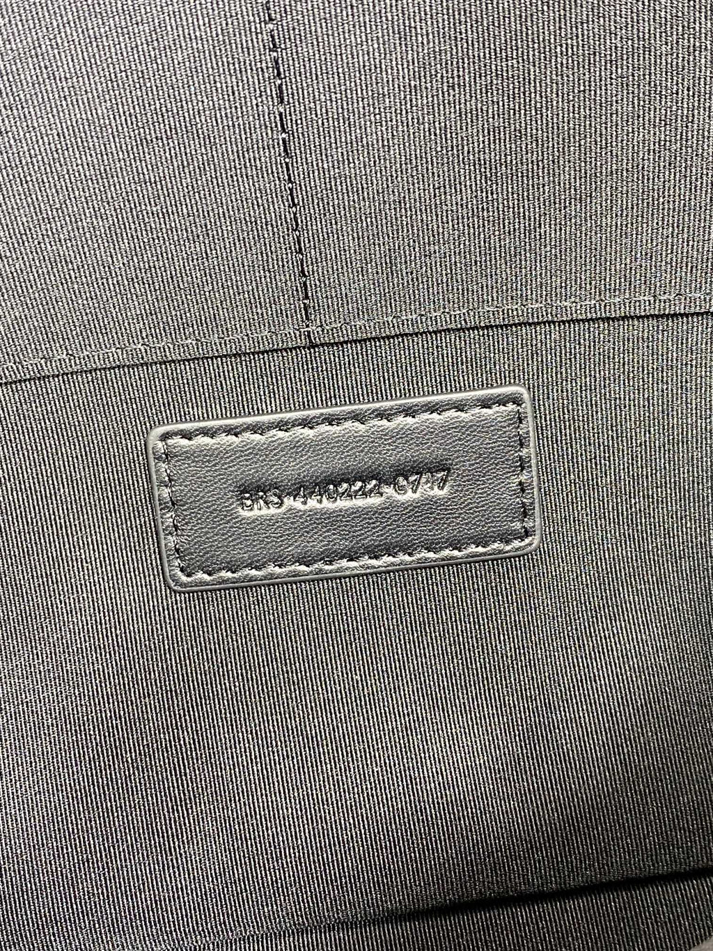 Close-up of interior label on small quilted bag, Saint Laurent Paris text