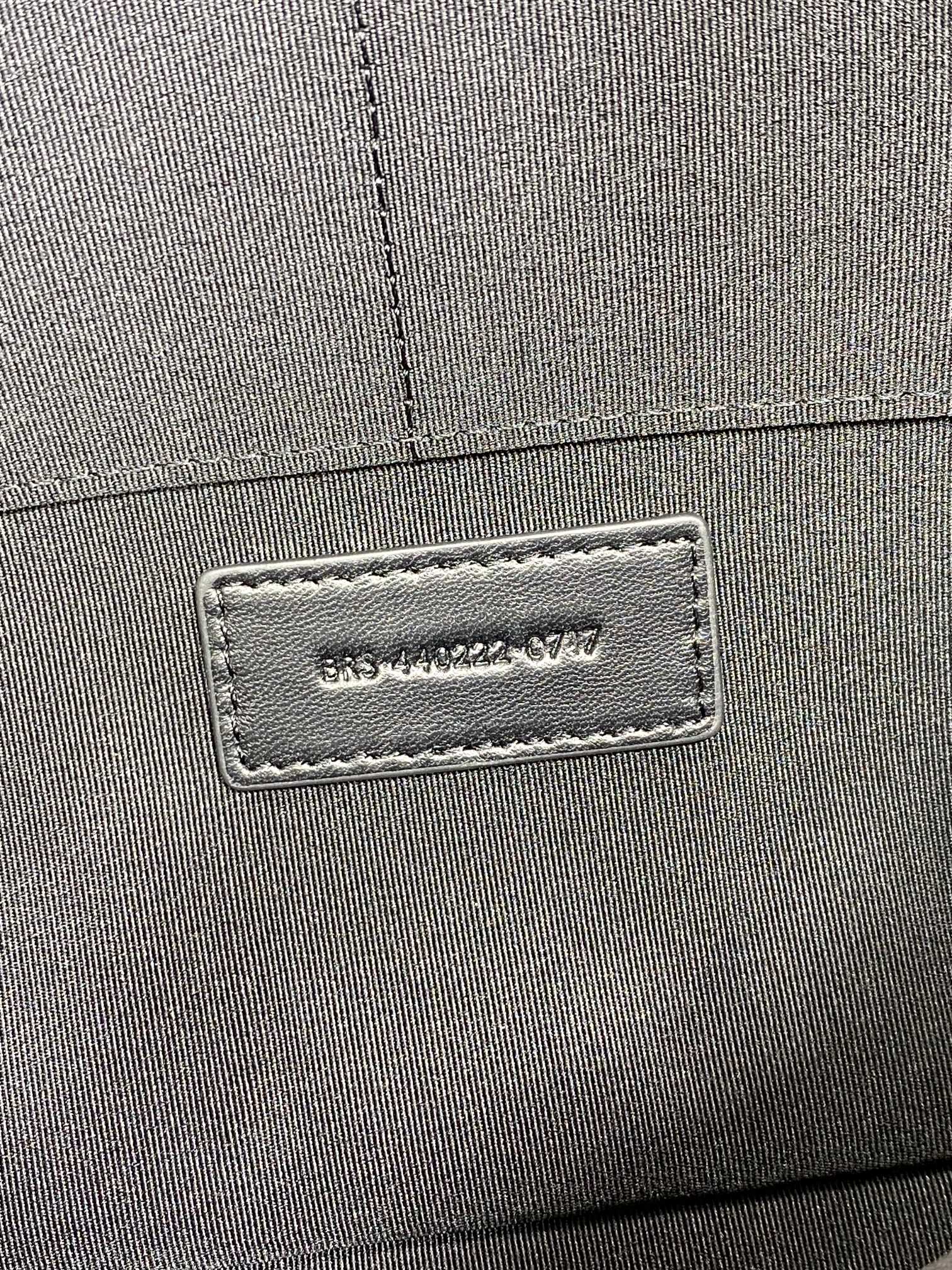 Close-up of interior label on small quilted bag, Saint Laurent Paris text