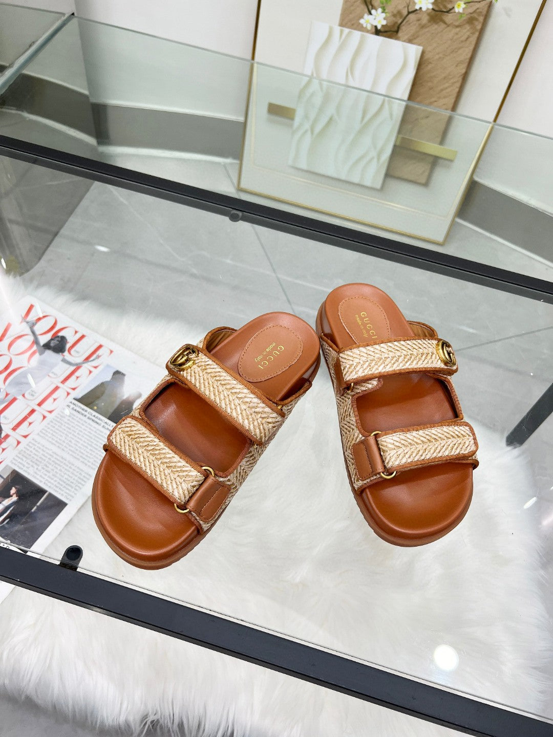 Gucci slide sandals with tan textured straps, adjustable buckles, and brown leather footbeds