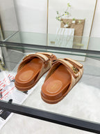 Gucci slide sandals with tan textured straps and brown leather footbed, side angle