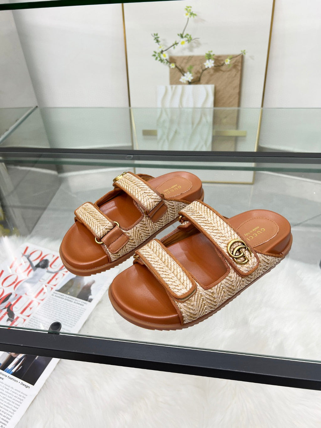Gucci slide sandals with tan textured straps, gold GG buckle, and brown slide base